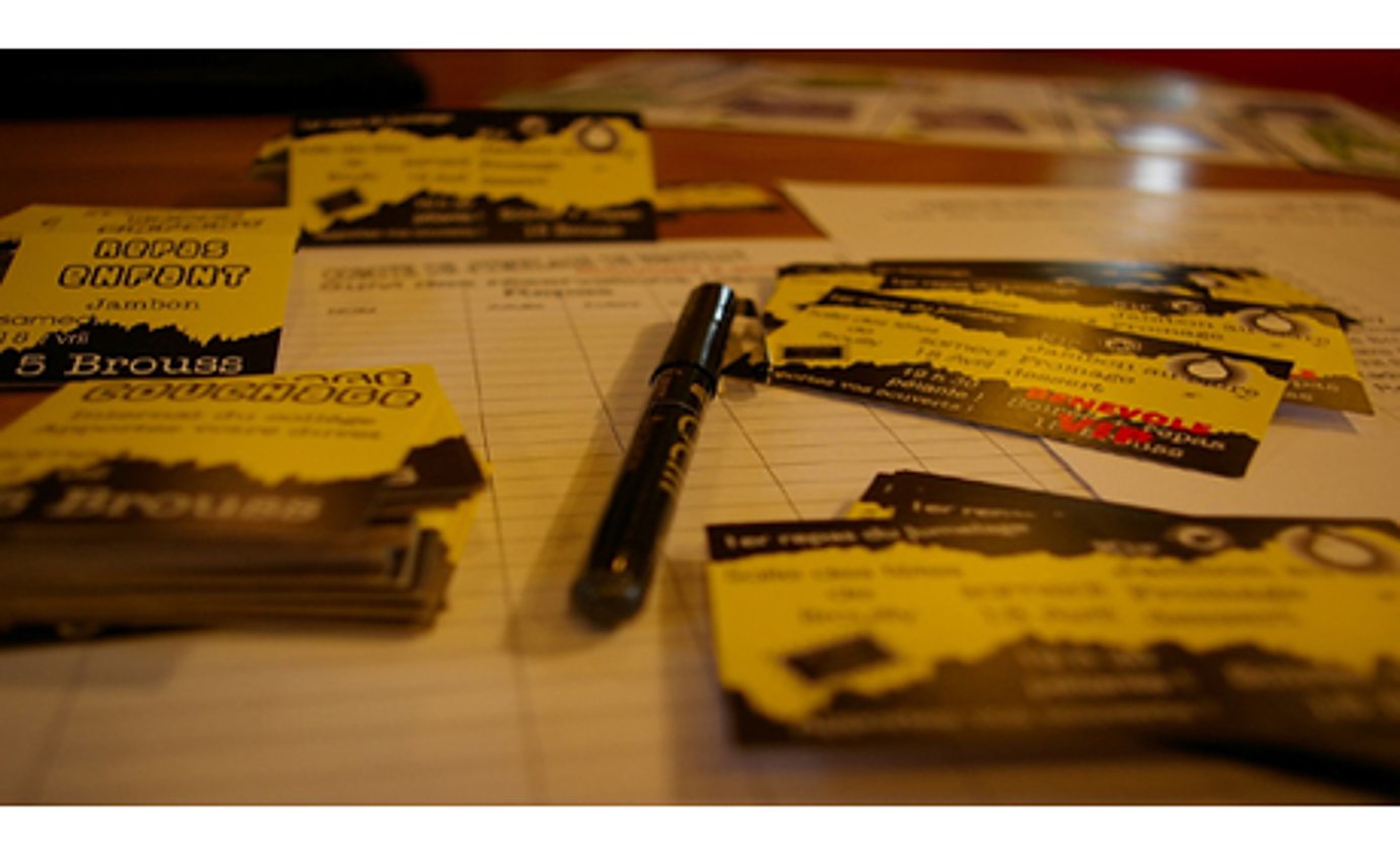 Des piles de cartes de visite jaunes et noires sont posées sur une feuille quadrillée, avec un feutre noir au centre de la table.